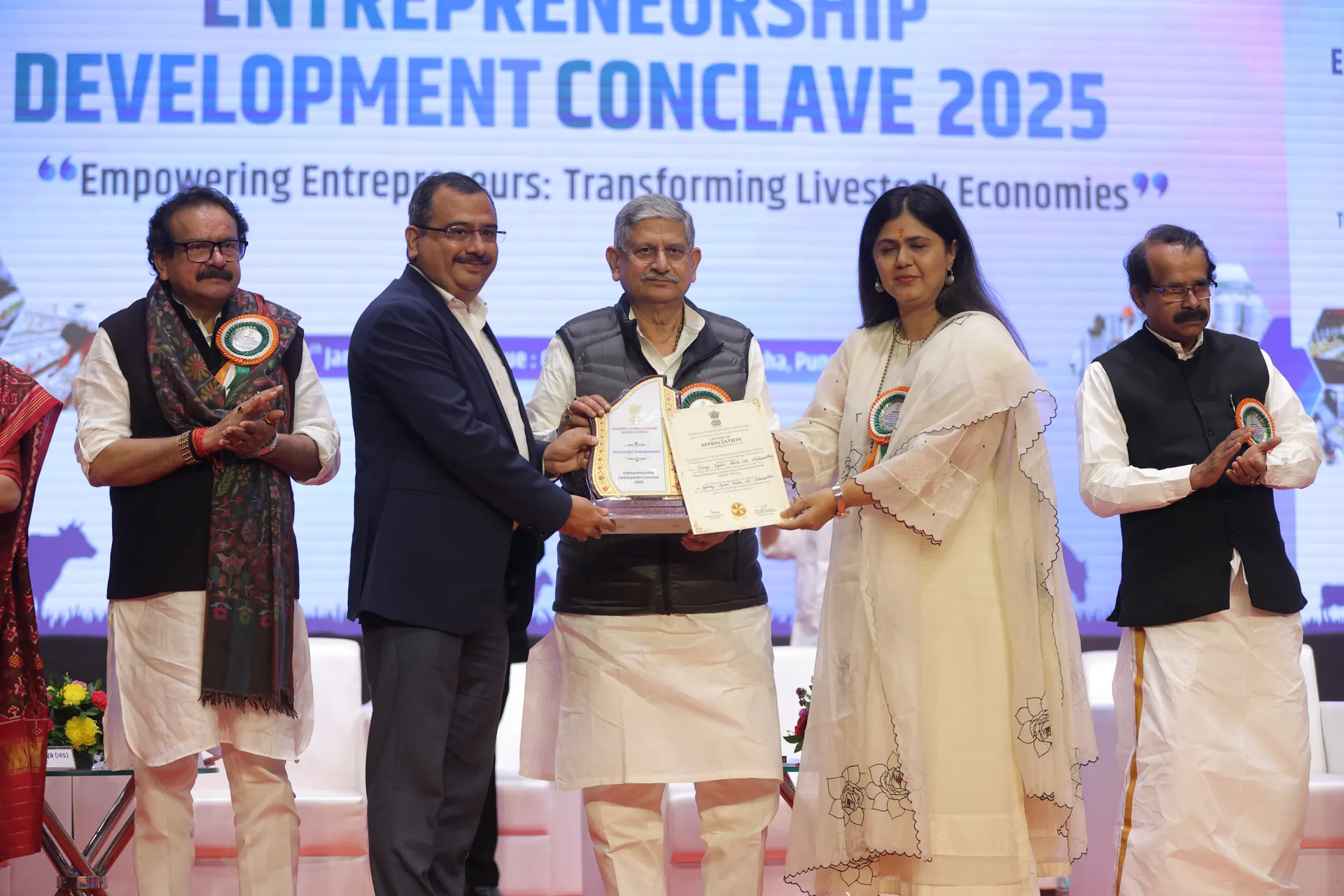 An award being presented on stage at the Entrepreneurship Development Conclave 2025